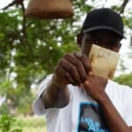Real editorial stock photograph illustrating cash and digital payment use; not a photograph of the Bank of Ghana pilot